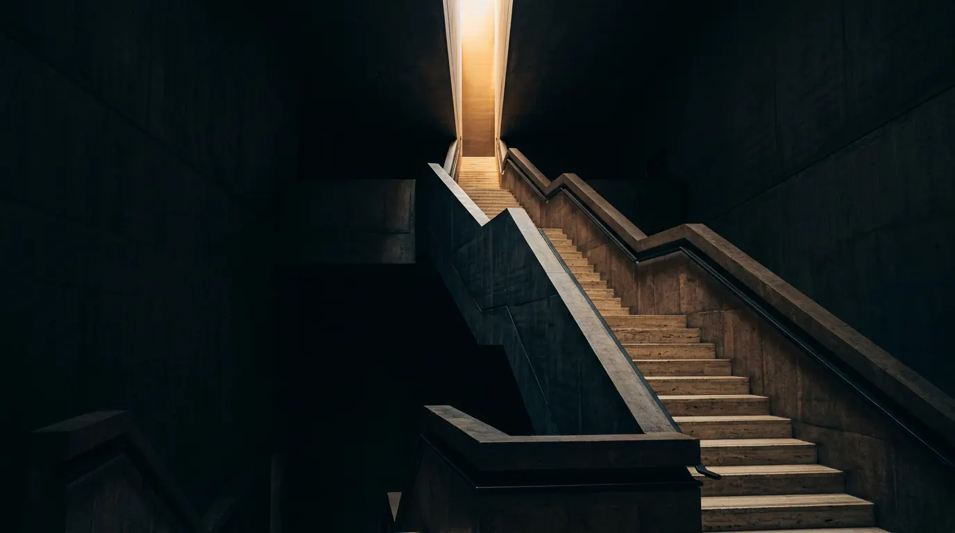 Escalier architectural montant vers une lumière dorée